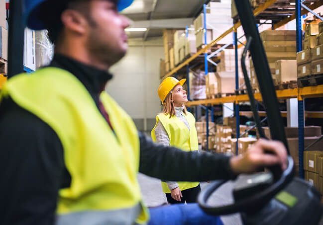 Man Driving Forklift in Warehouse